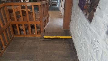 Route to the back of the Mill with one step with a yellow visual contrast stripe. It is too narrow for most wheelchairs.