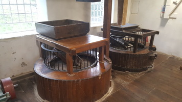 Two wooden quern stones for grinding wheat. These are not in use anymore and have bars on them.